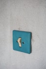 a blue light switch on a white wall