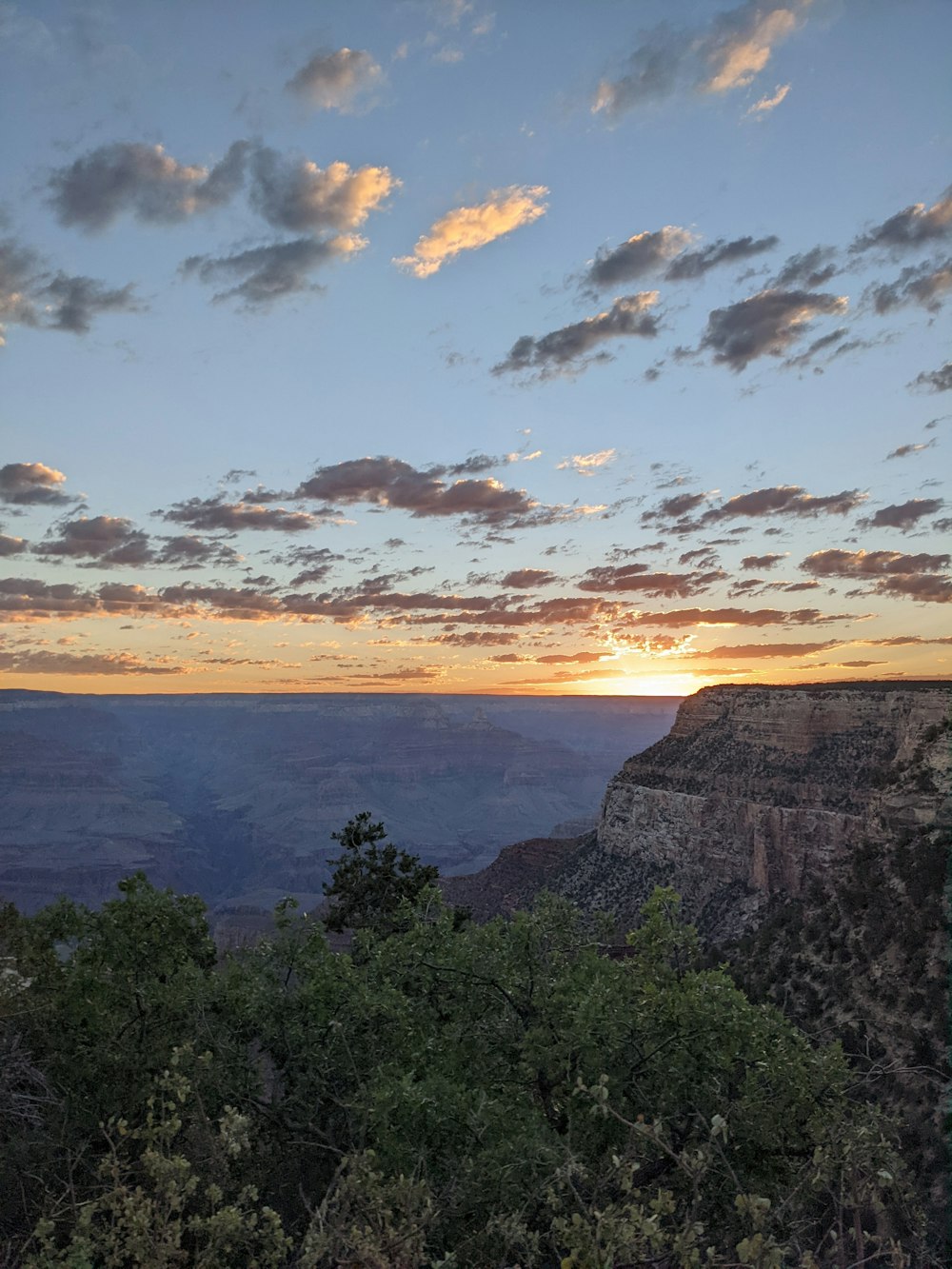 the sun is setting over the grand canyon