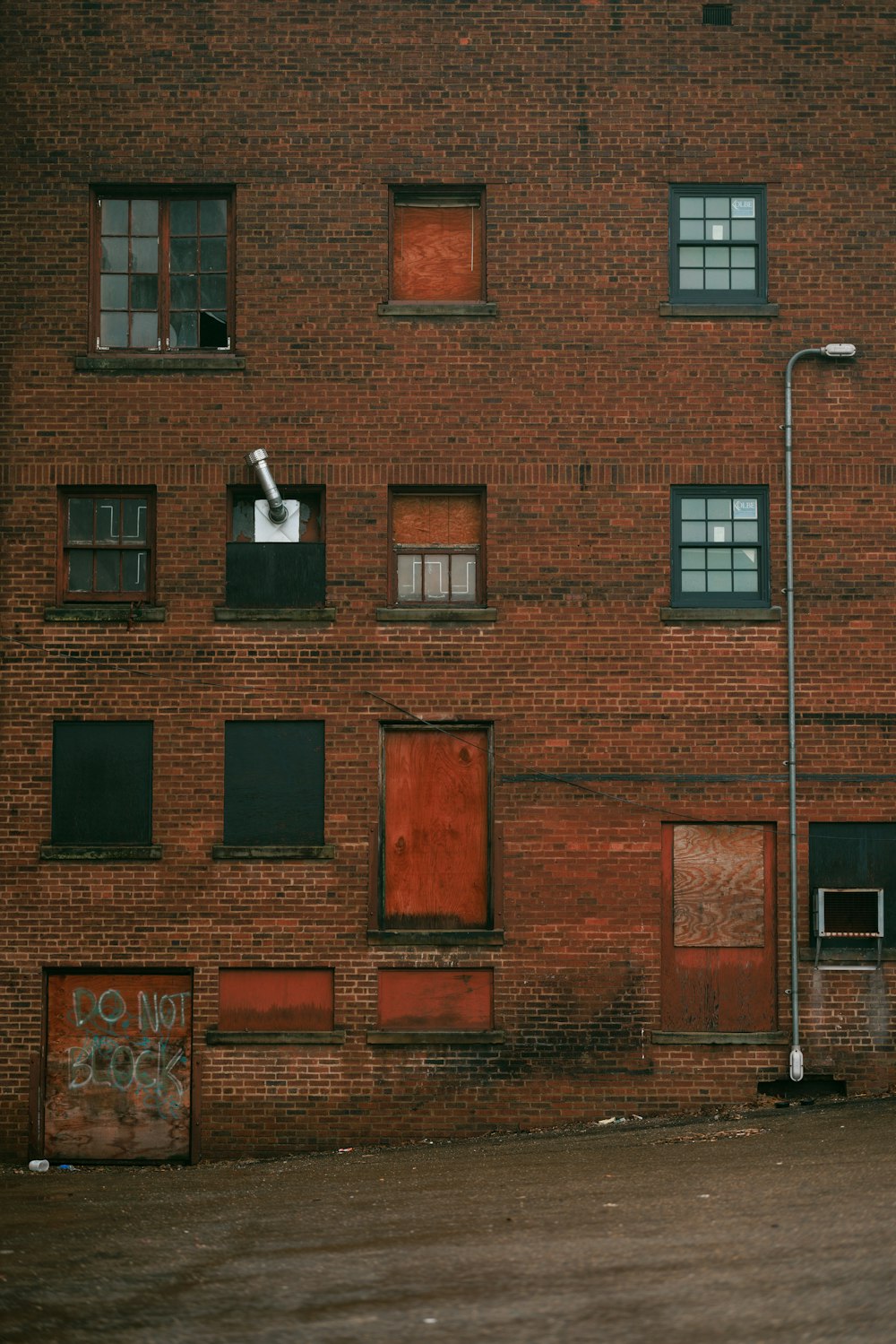 a man riding a skateboard past a tall brick building