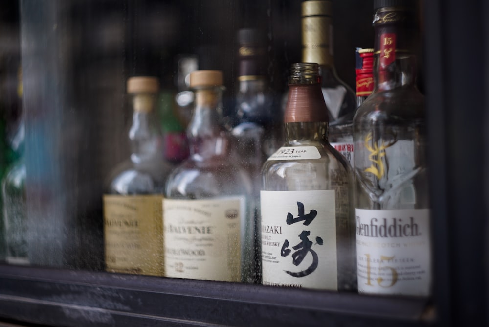 bottles of alcohol are lined up on a shelf