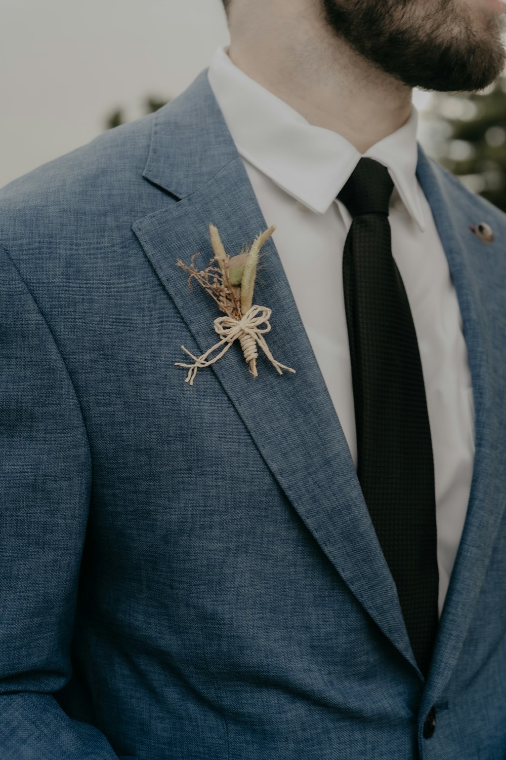 a man wearing a suit and tie with a boutonniere