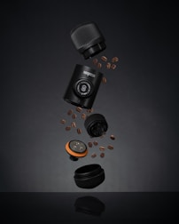 a camera and some coffee beans on a table