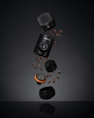 a camera and some coffee beans on a table