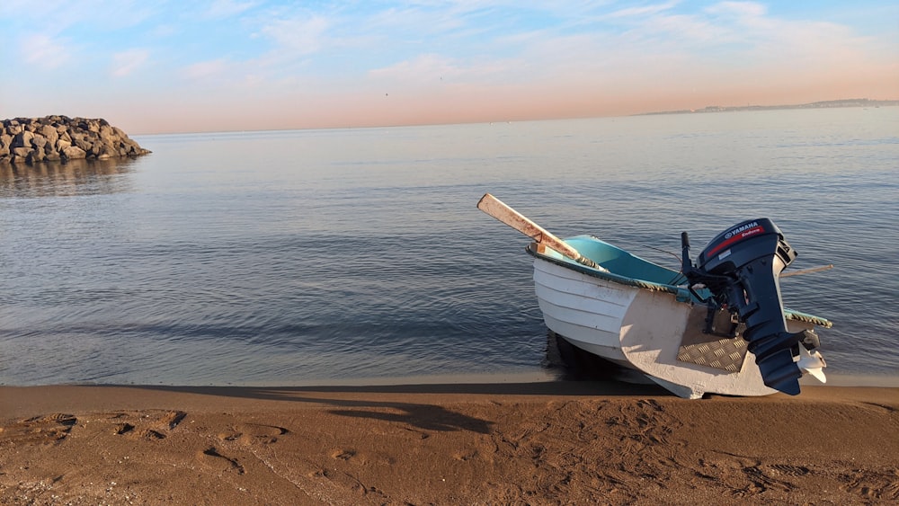 una piccola barca seduta sulla cima di una spiaggia sabbiosa