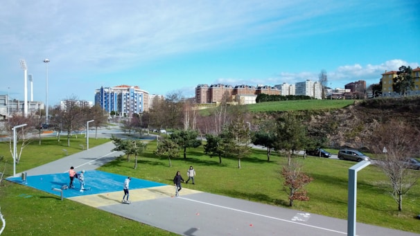 Children playing joyfully in a sunlit community park surrounded by colorful buildings