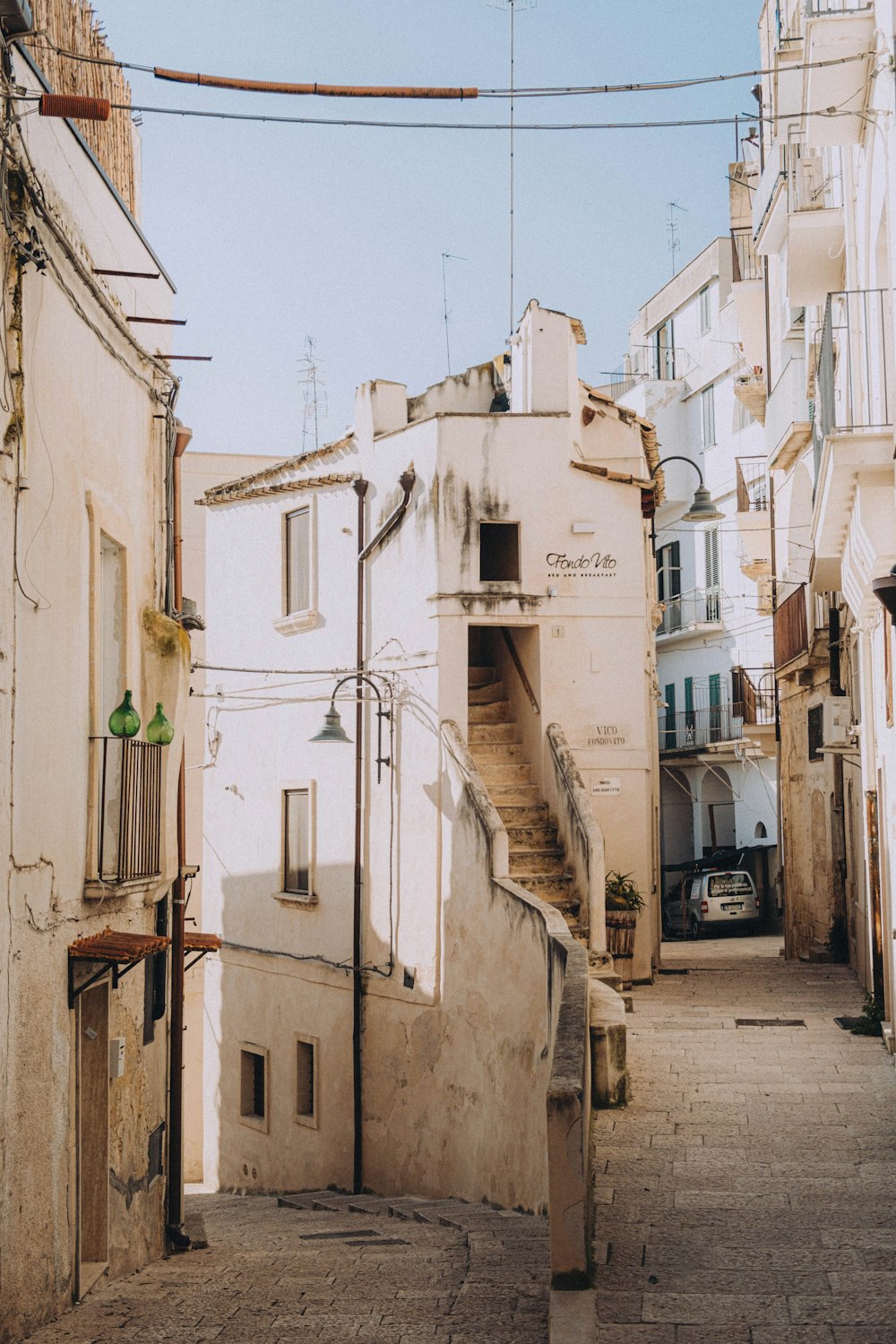 a narrow street with a car parked on the side of it