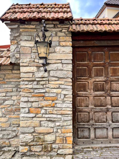 A tranquil rustic scene featuring an antique lantern hanging beside aged stone walls