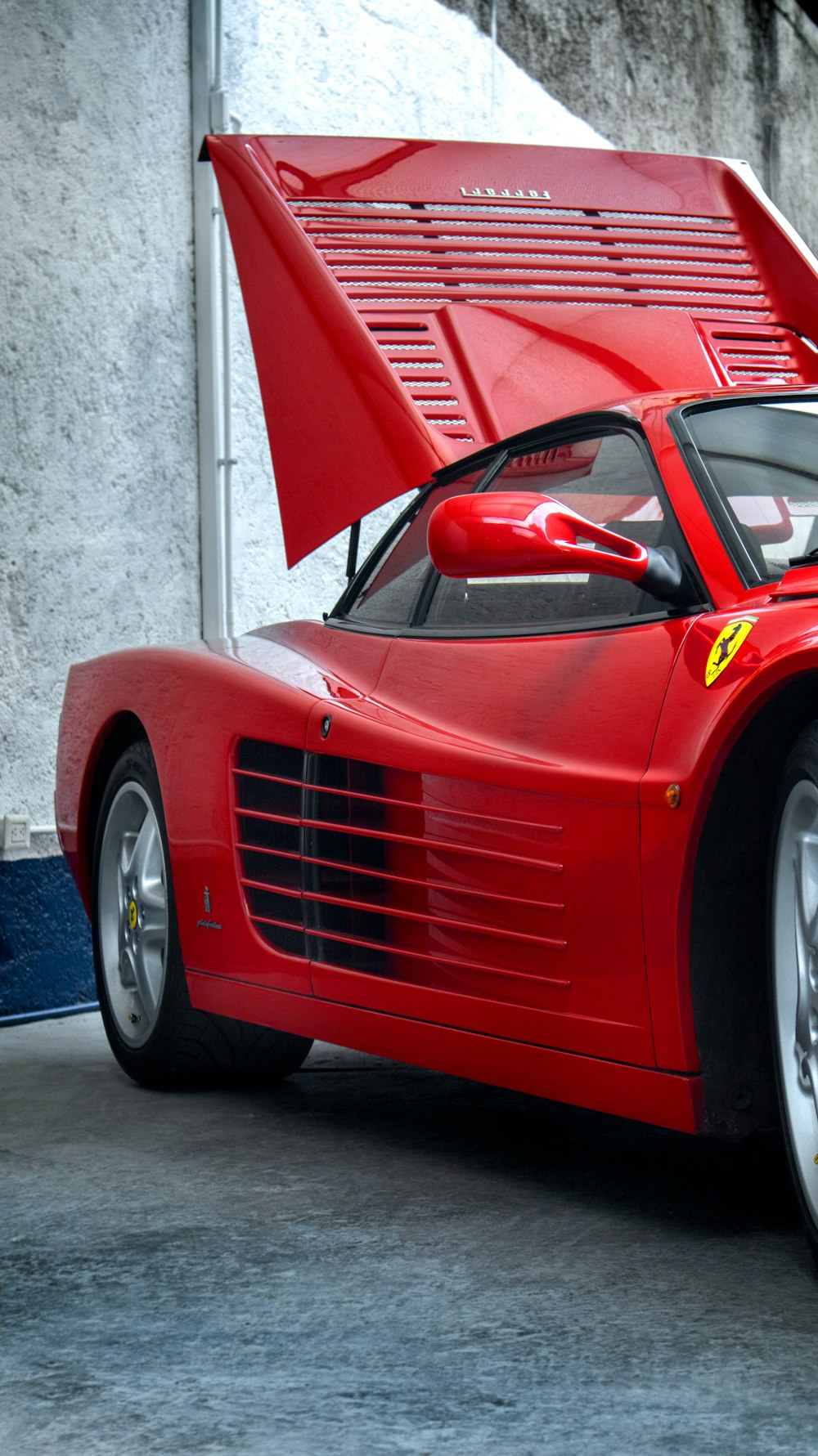 a red sports car with its hood open