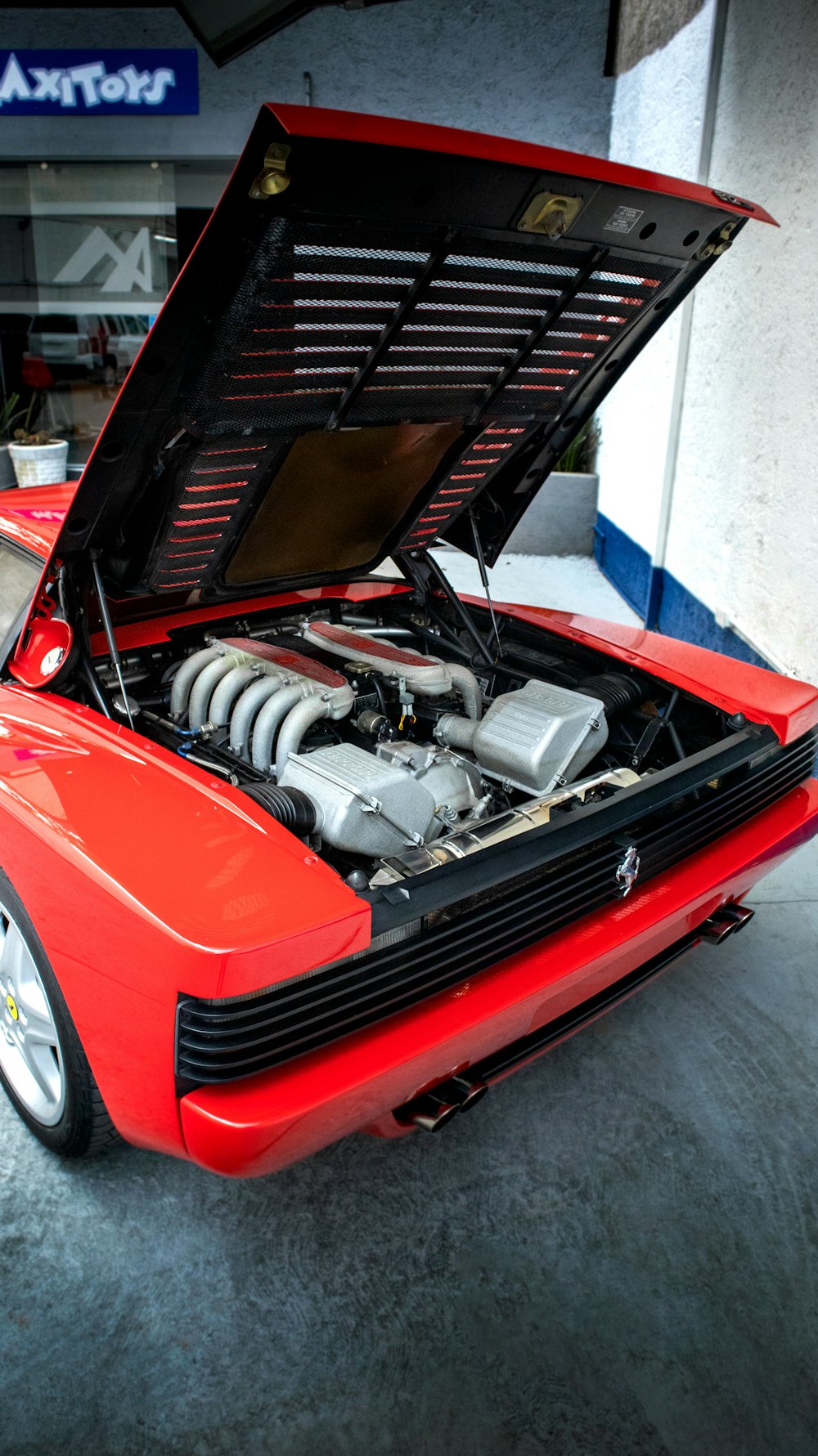 a red sports car with its hood open