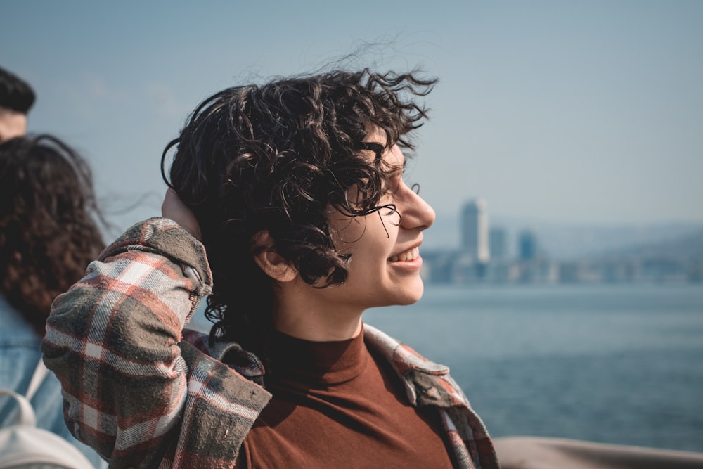 a man with curly hair and glasses talking on a cell phone