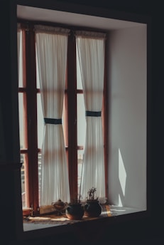 a window with two vases sitting on a window sill