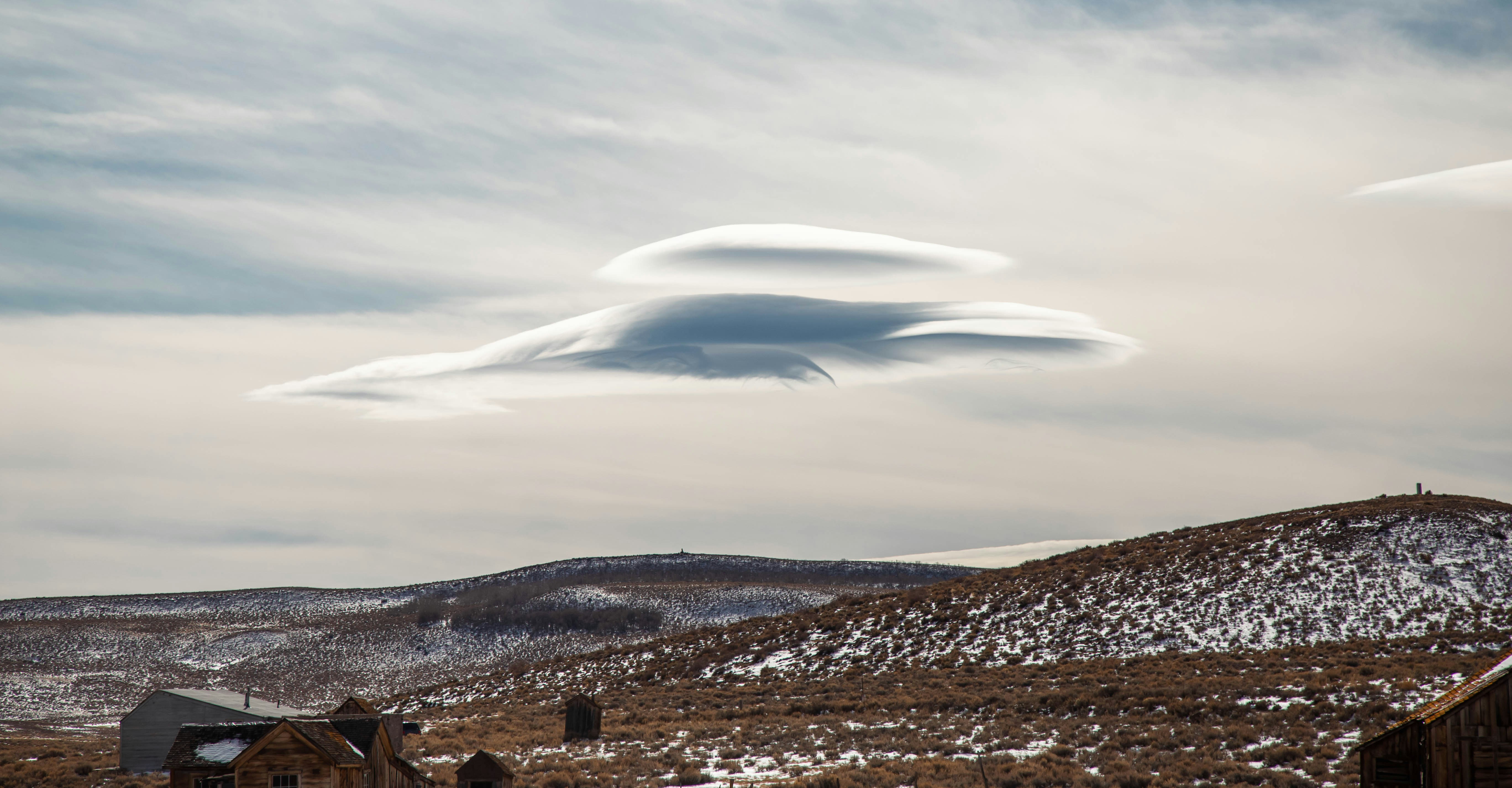a large cloud in the sky over a mountain