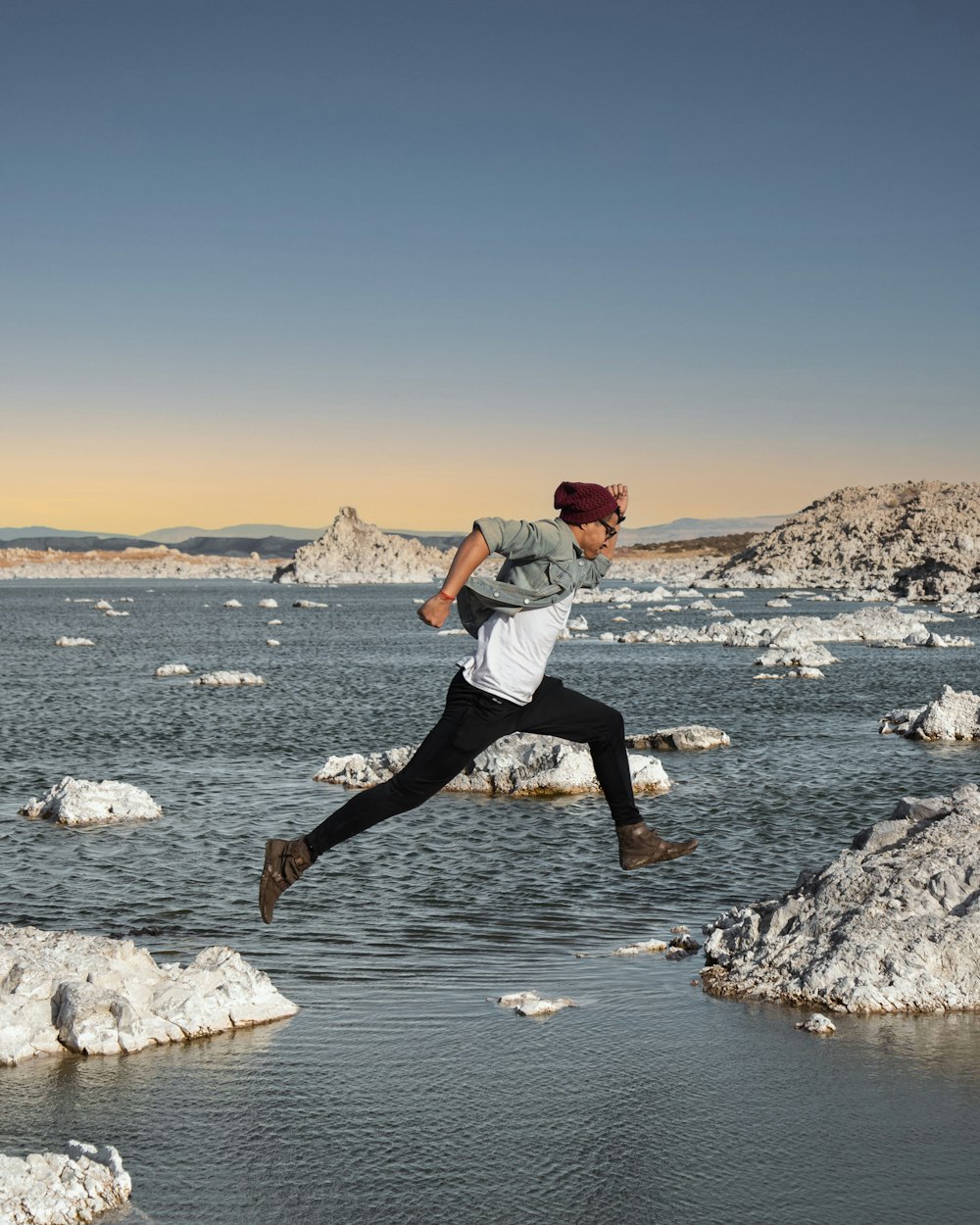 a man jumping in the air over a body of water