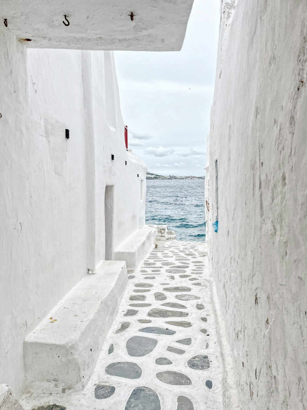 a white building with a stone pathway leading to the water