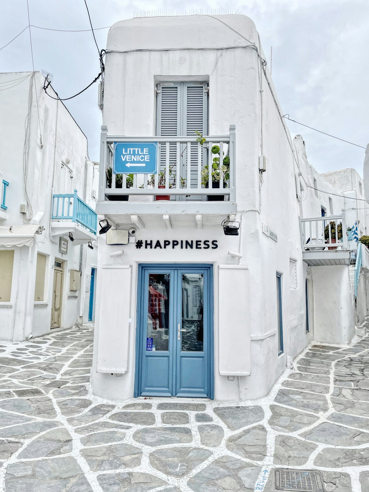 Mykonos March — white building with blue door in Chora town as the island begins its spring awakening