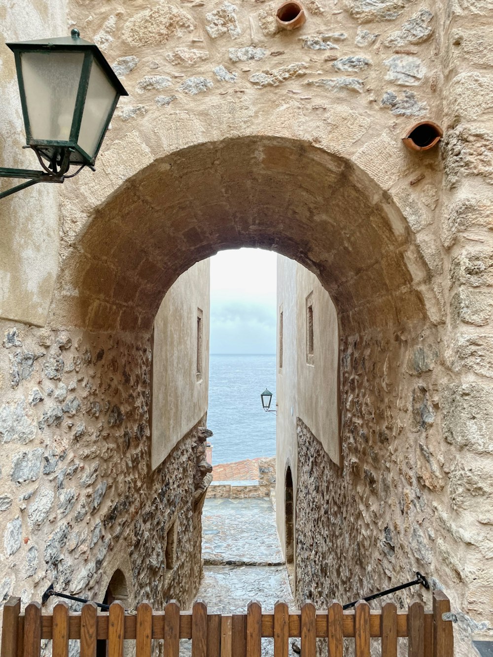 a stone building with a wooden gate and a light