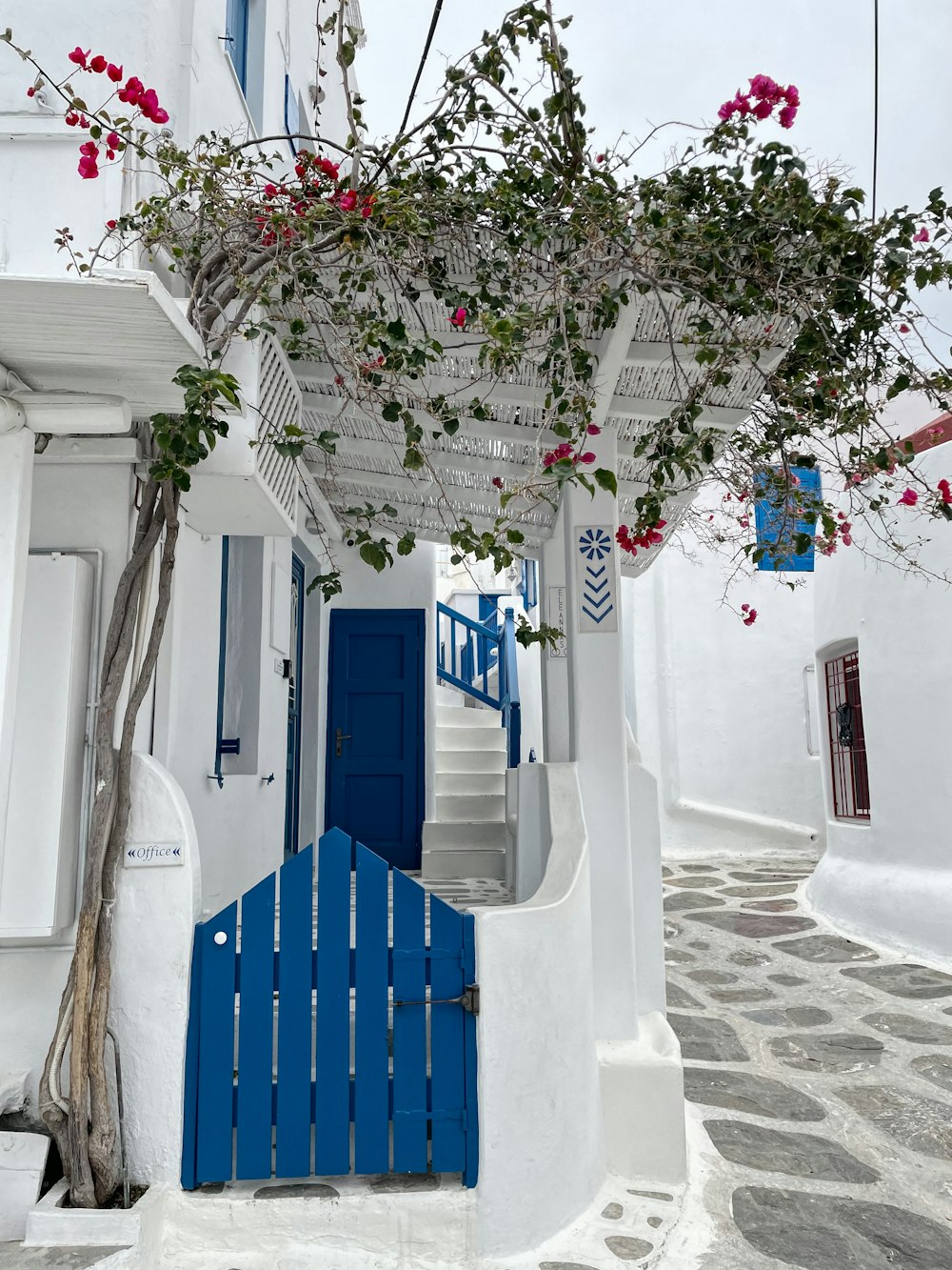 a white building with a blue door and stairs