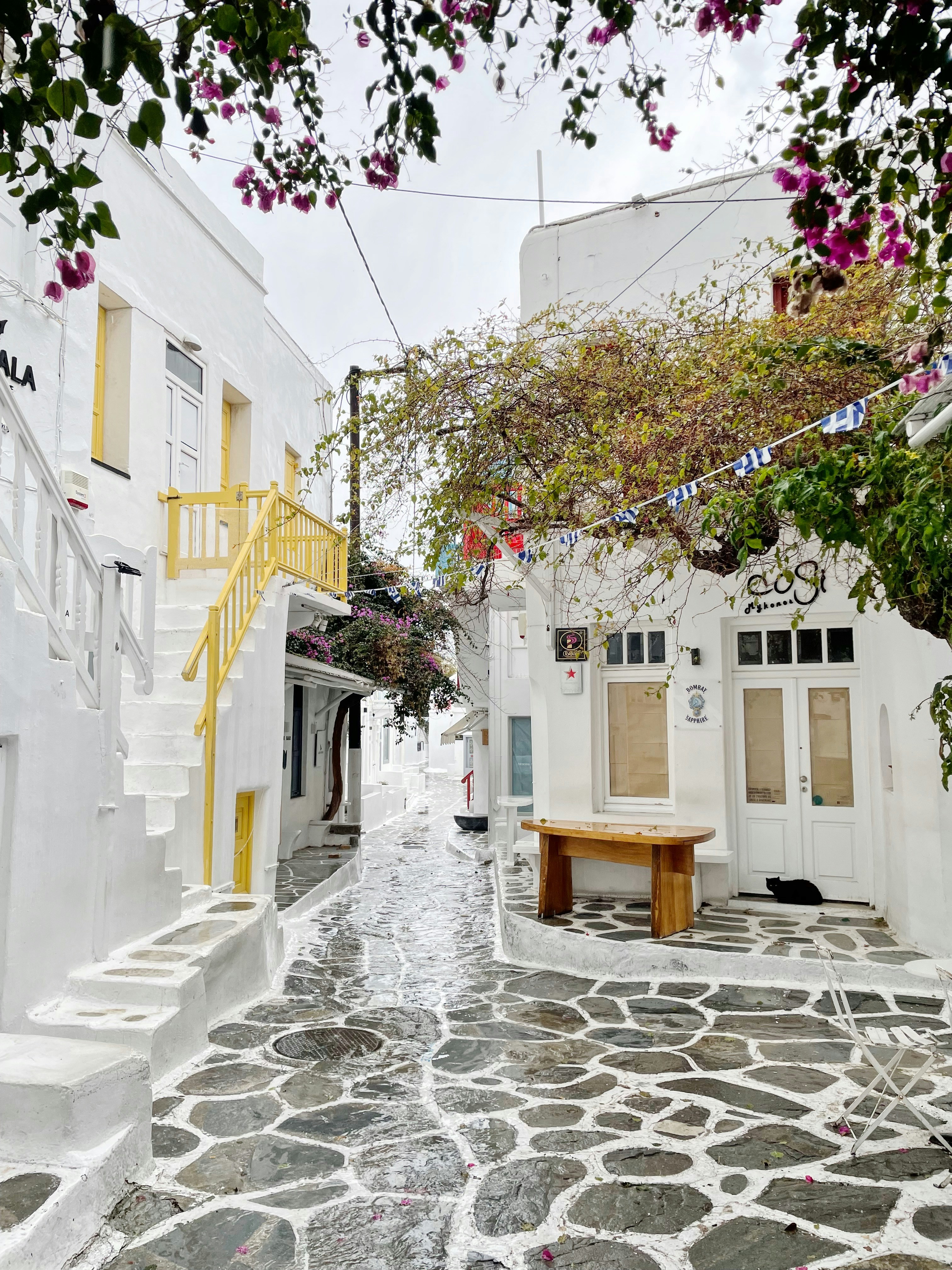 a cobblestone street lined with white buildings
