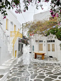 a cobblestone street lined with white buildings
