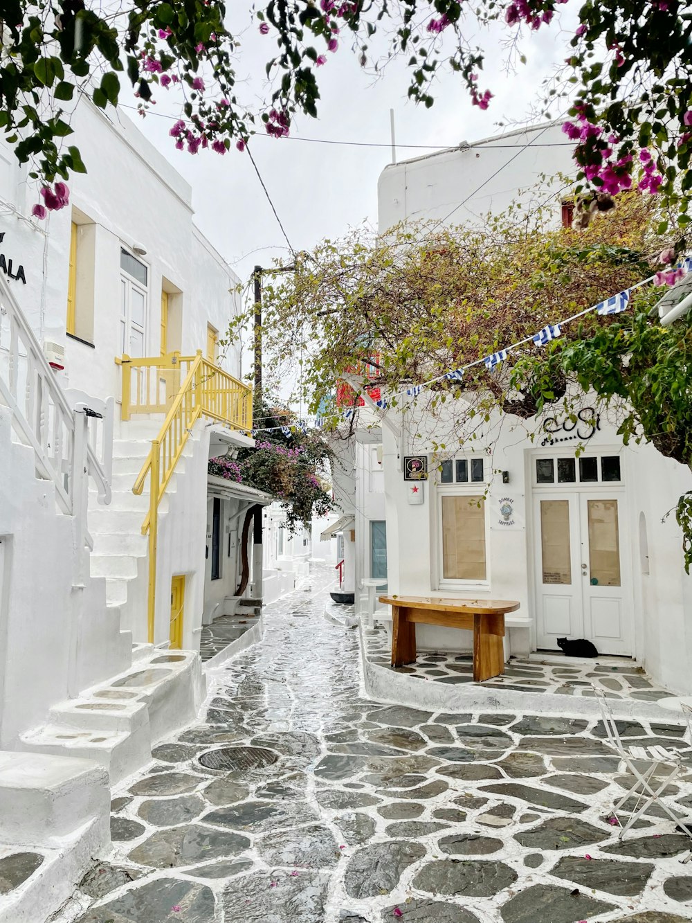 a cobblestone street lined with white buildings