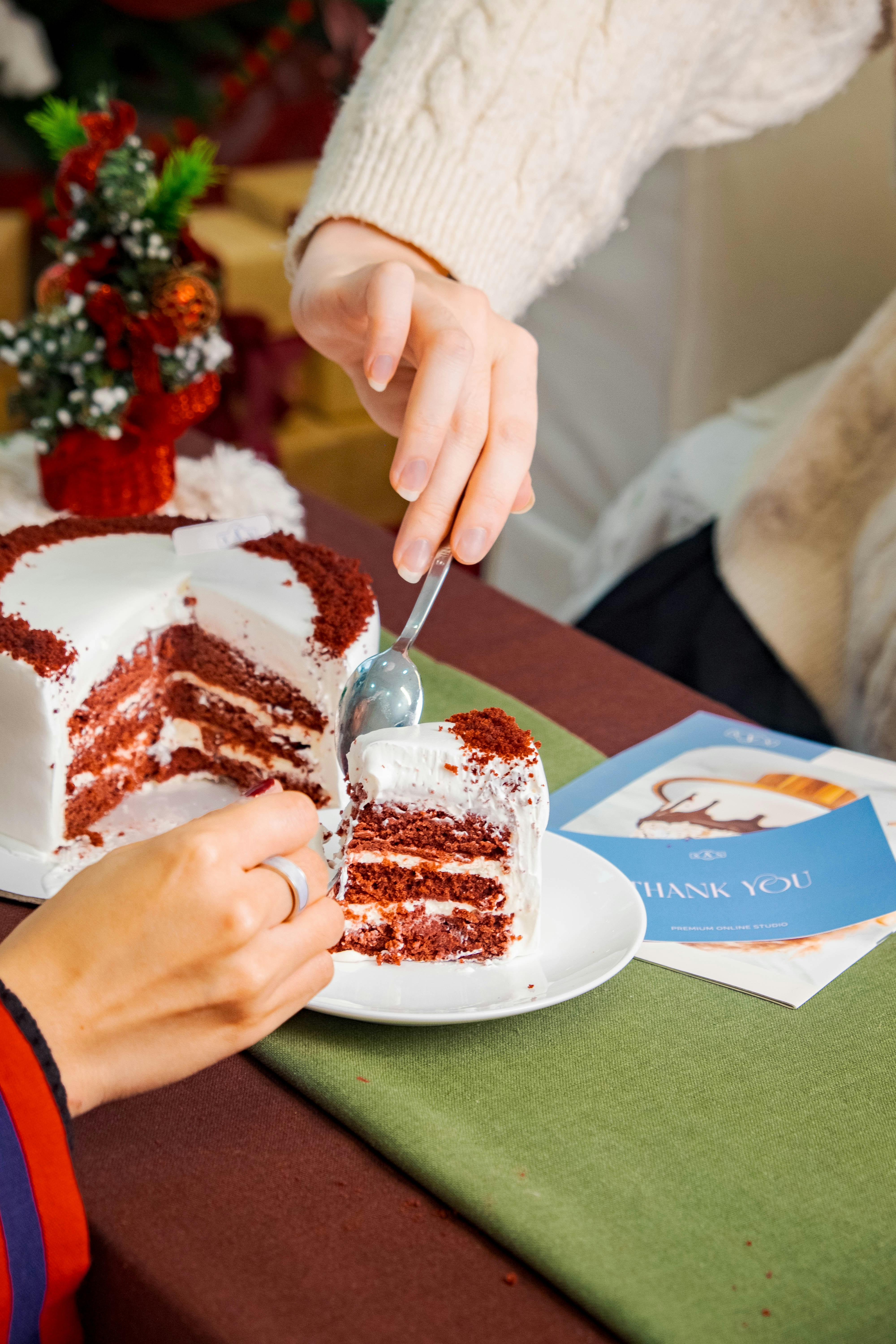 a person cutting a piece of cake with a knife