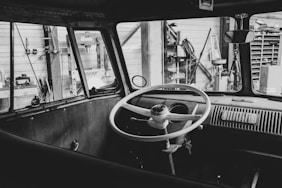 a black and white photo of a steering wheel and dashboard