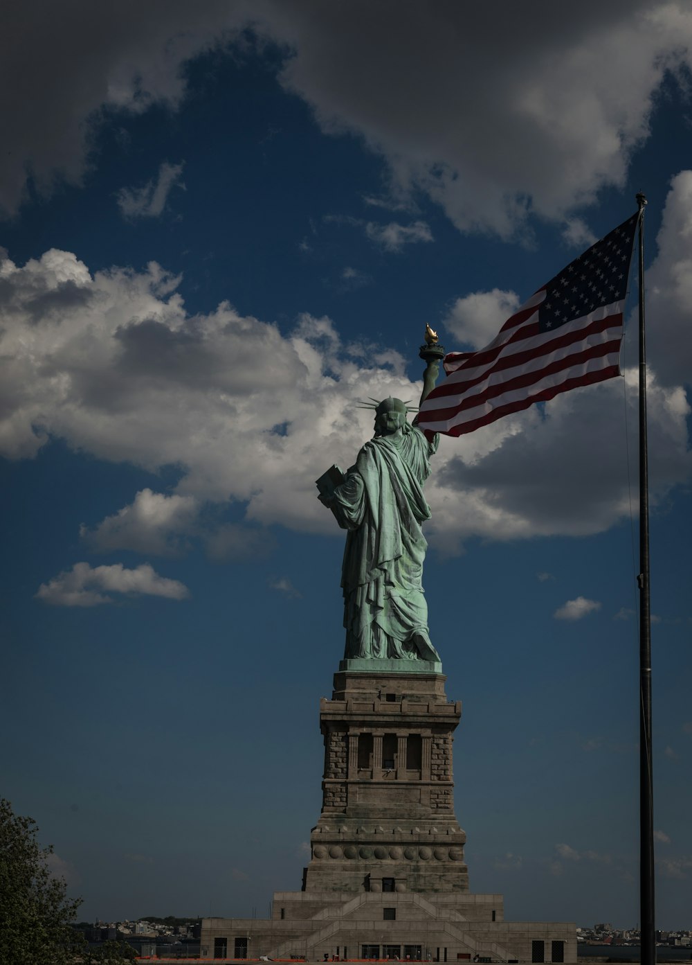 a statue of liberty with a flag flying in front of it