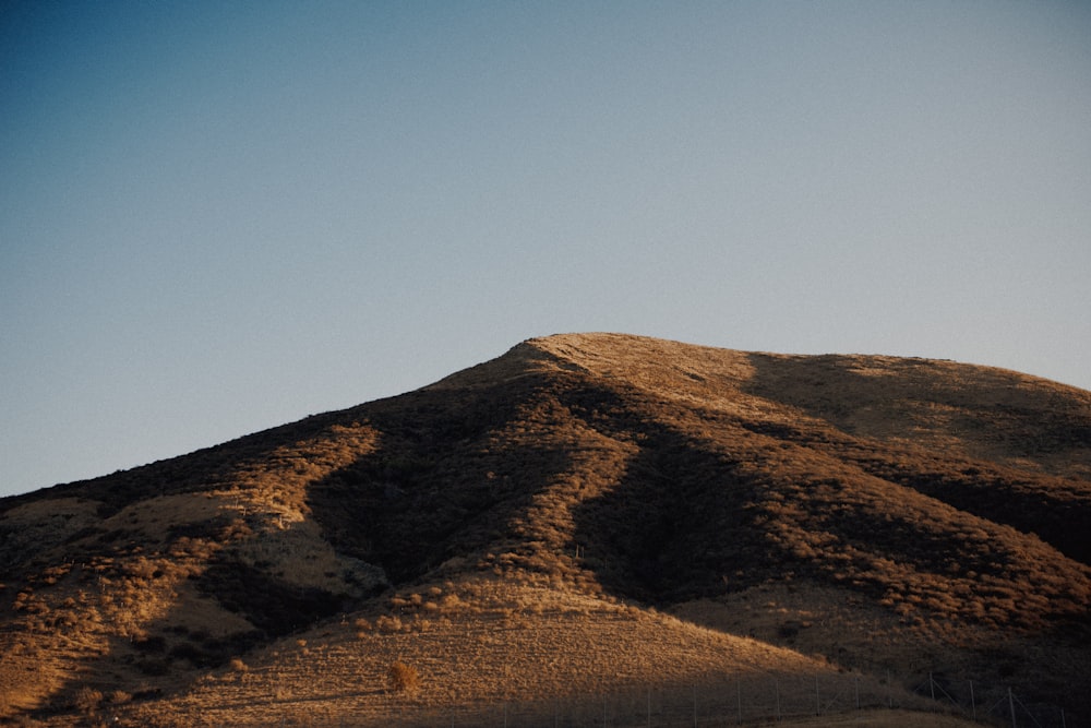 a hill with a blue sky in the background