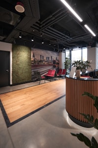 a room with a desk, chairs, and a wall mural