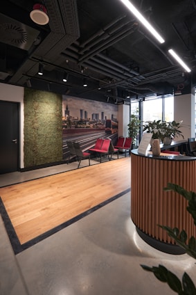 a room with a desk, chairs, and a wall mural