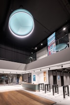 A modern, minimalist office lobby with subtle teal and blue lighting reflecting the brand colors.