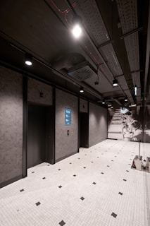 a room with a tiled floor and two elevators