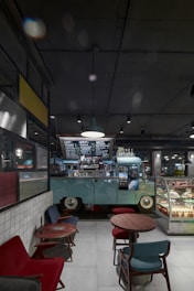 A delivery van parked outside a bustling café, with fresh cakes and desserts being unloaded by friendly staff.