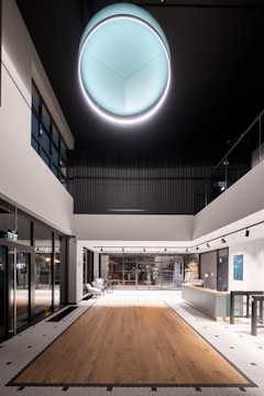 a large room with a wooden floor and a round light fixture