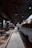 A modern, stylish cafe with an industrial design features a retro van converted into a seating or serving area. Comfortable chairs and small tables line one side, while pendant lights and exposed ceilings create an urban vibe.