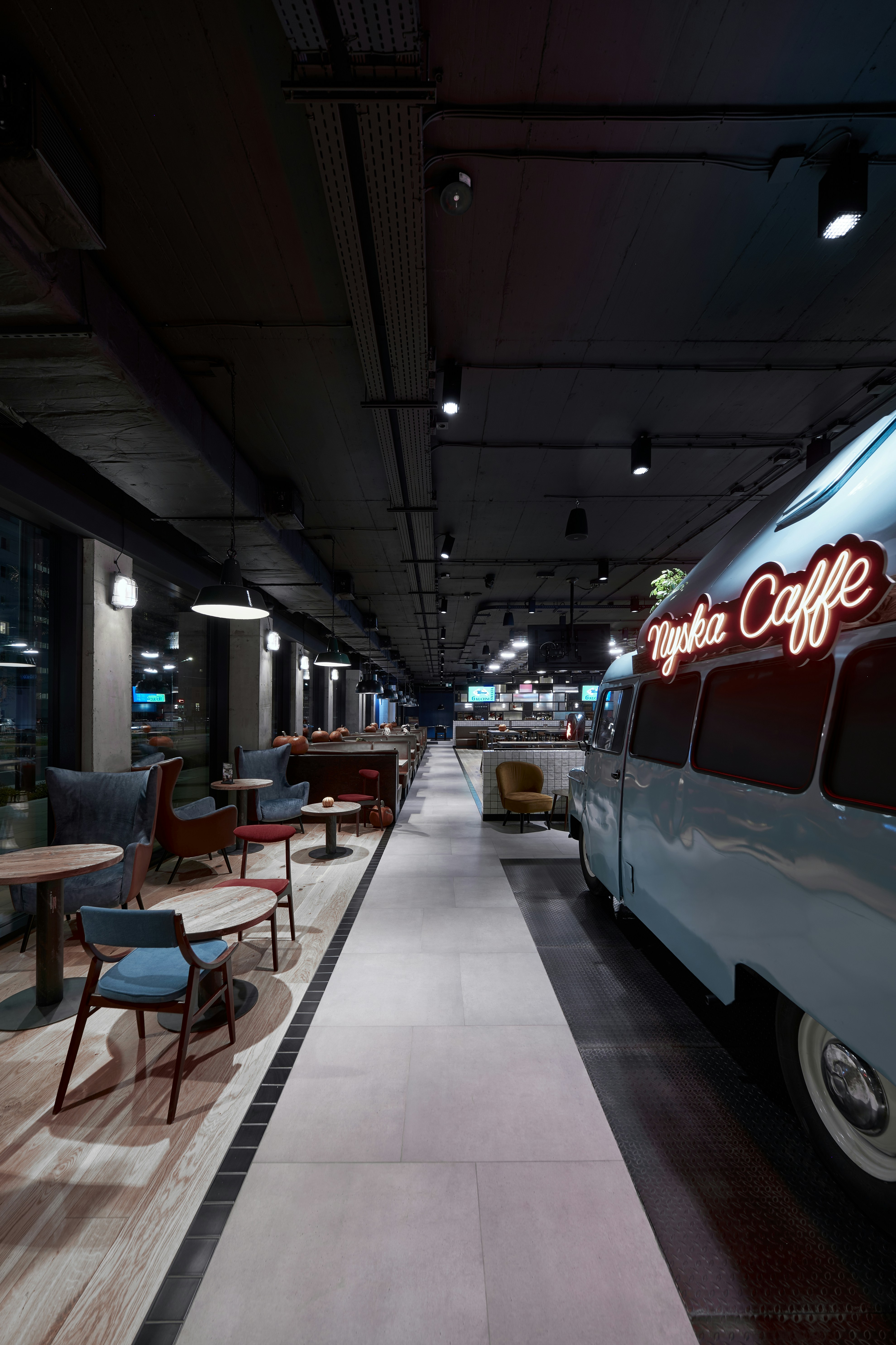 a bus parked in a parking garage next to a table and chairs