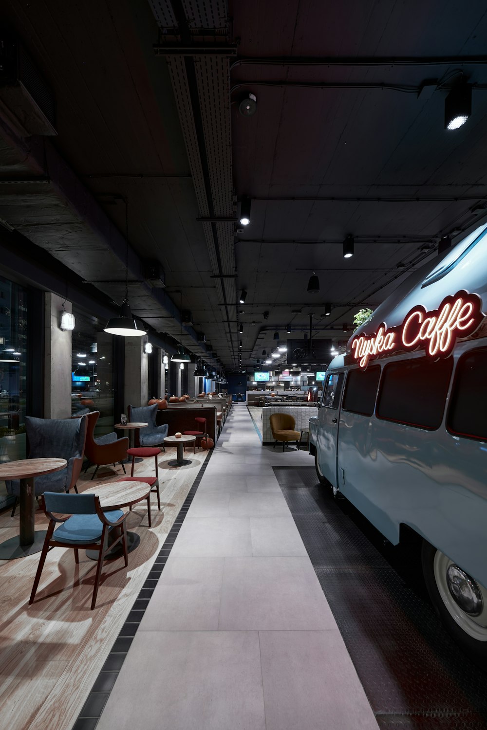 a bus parked in a parking garage next to a table and chairs