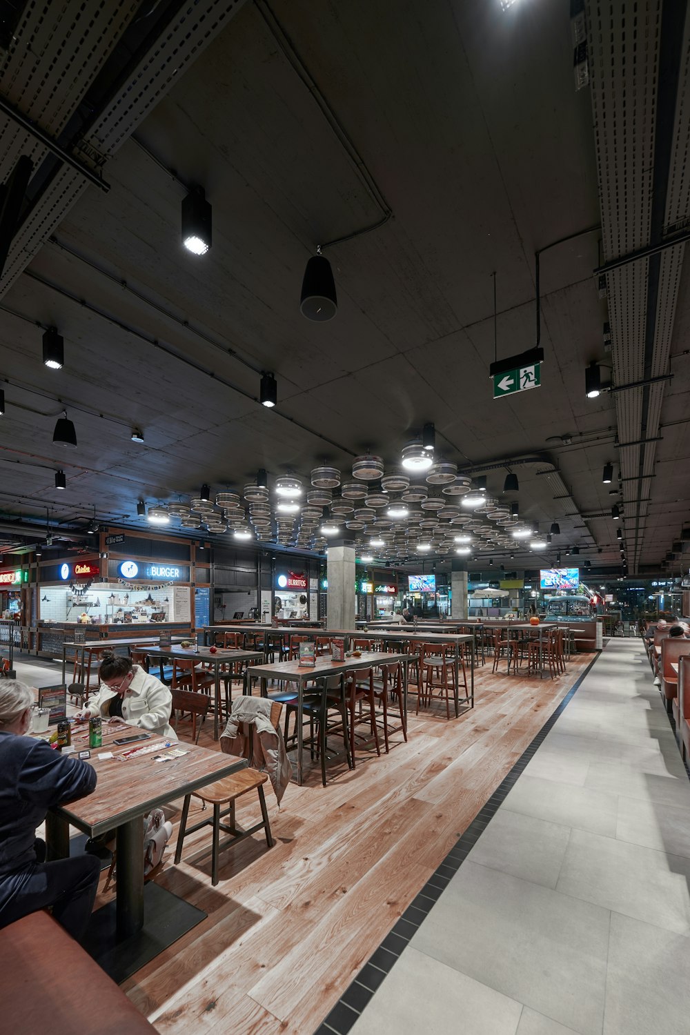 a restaurant with tables and chairs and people eating