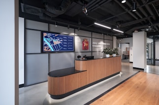 Modern office reception area with computers and customer service desk.
