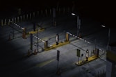 a parking lot at night with a lot of parking meters