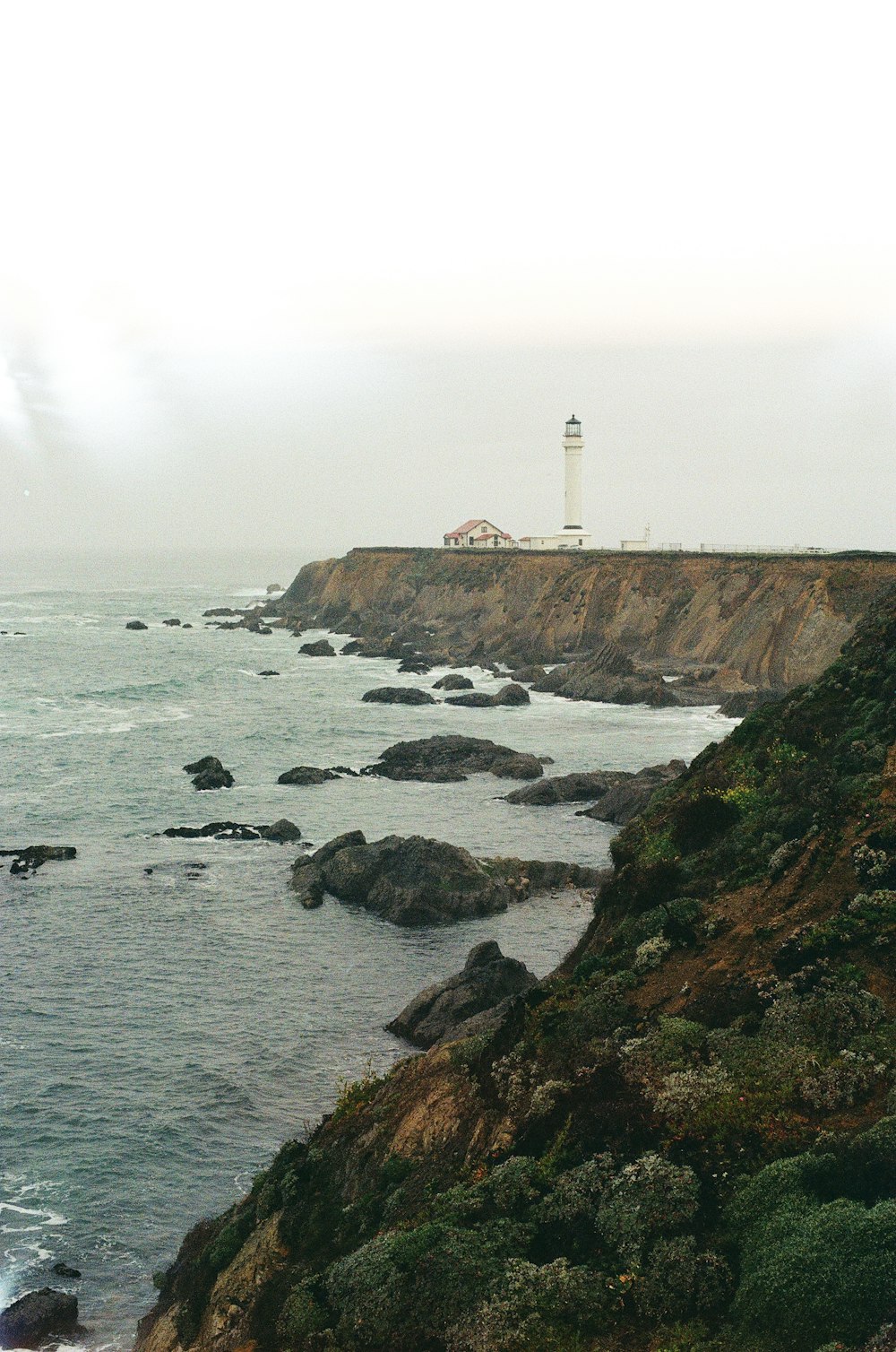 a light house on a cliff overlooking the ocean