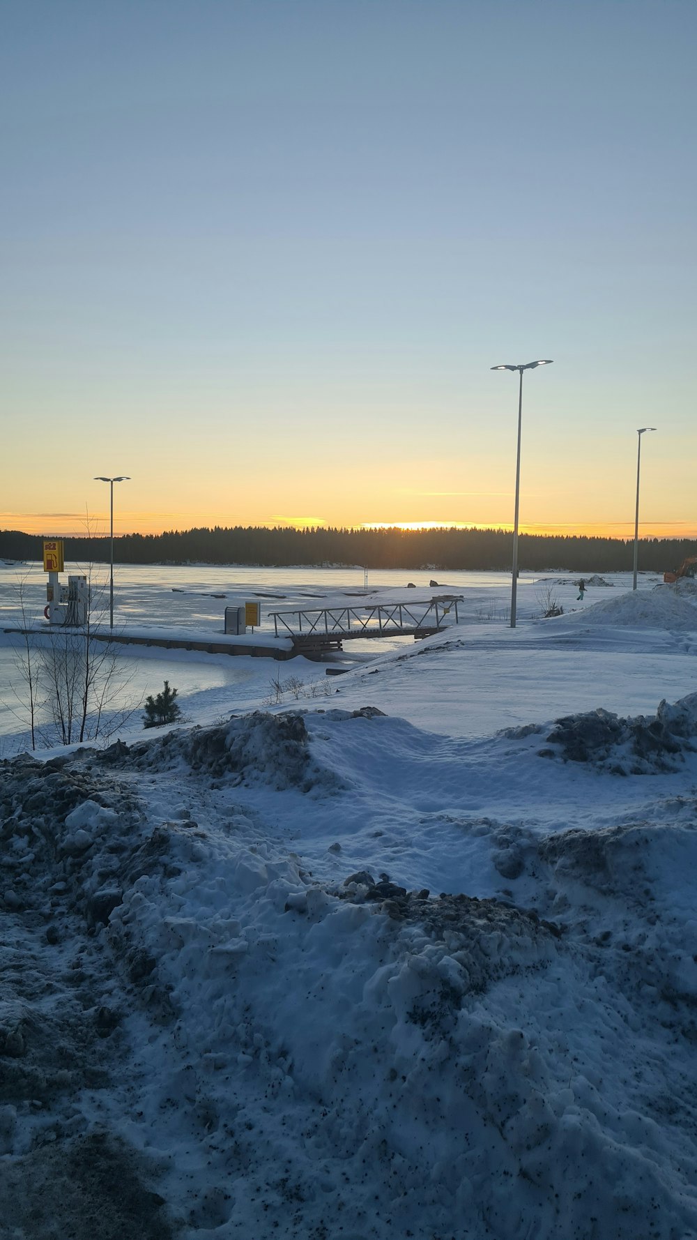 the sun is setting over a frozen lake