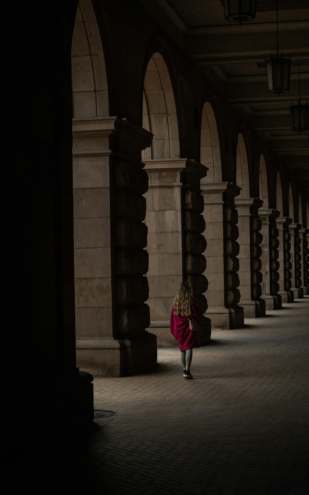 a woman in a red coat is walking down the street