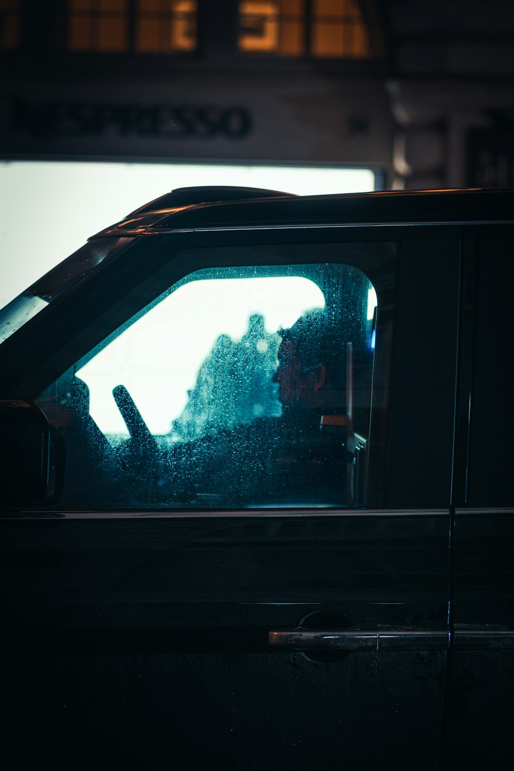 a person sitting in a car at night