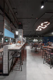 a restaurant with tables and stools and lights