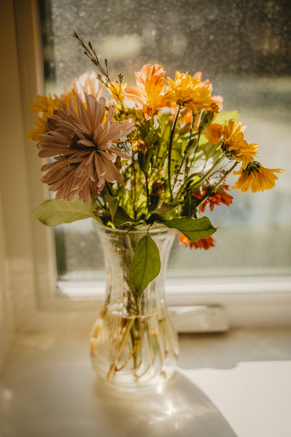 a vase of flowers sitting on a window sill