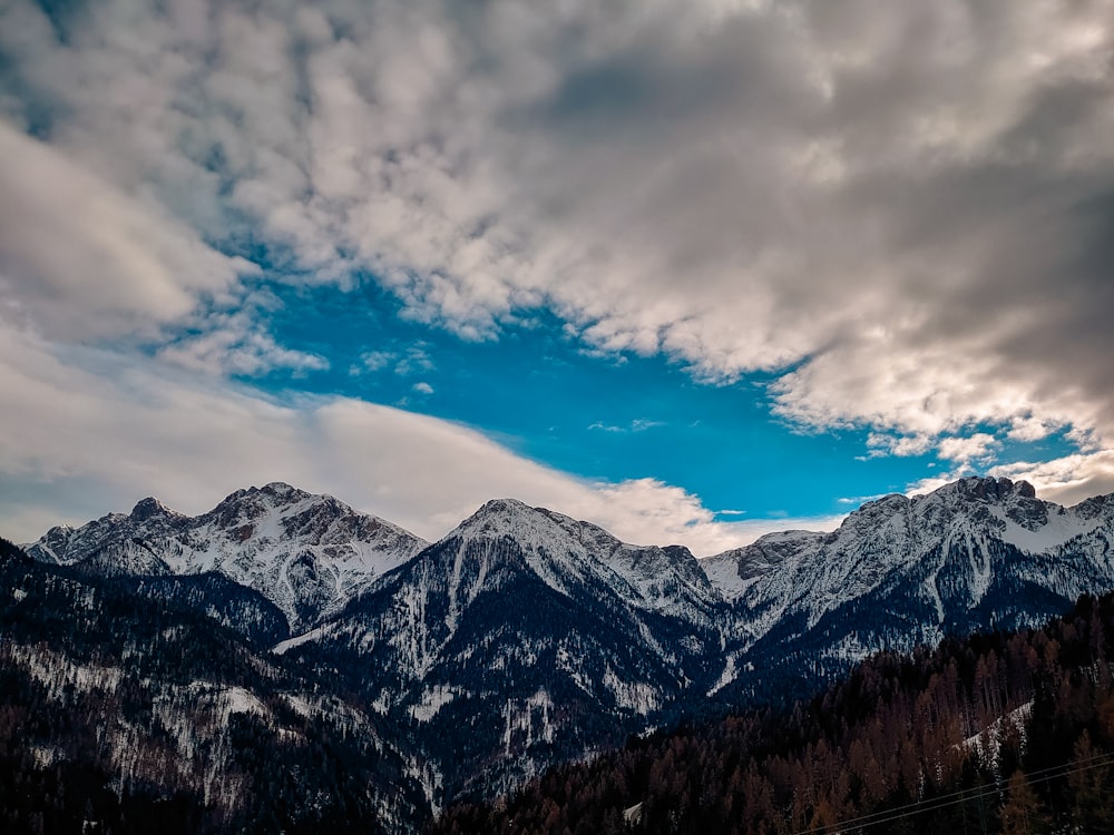 the mountains are covered in snow and clouds