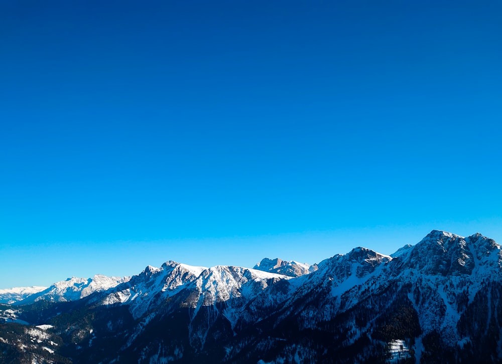 a view of a snowy mountain range with a ski lift in the foreground