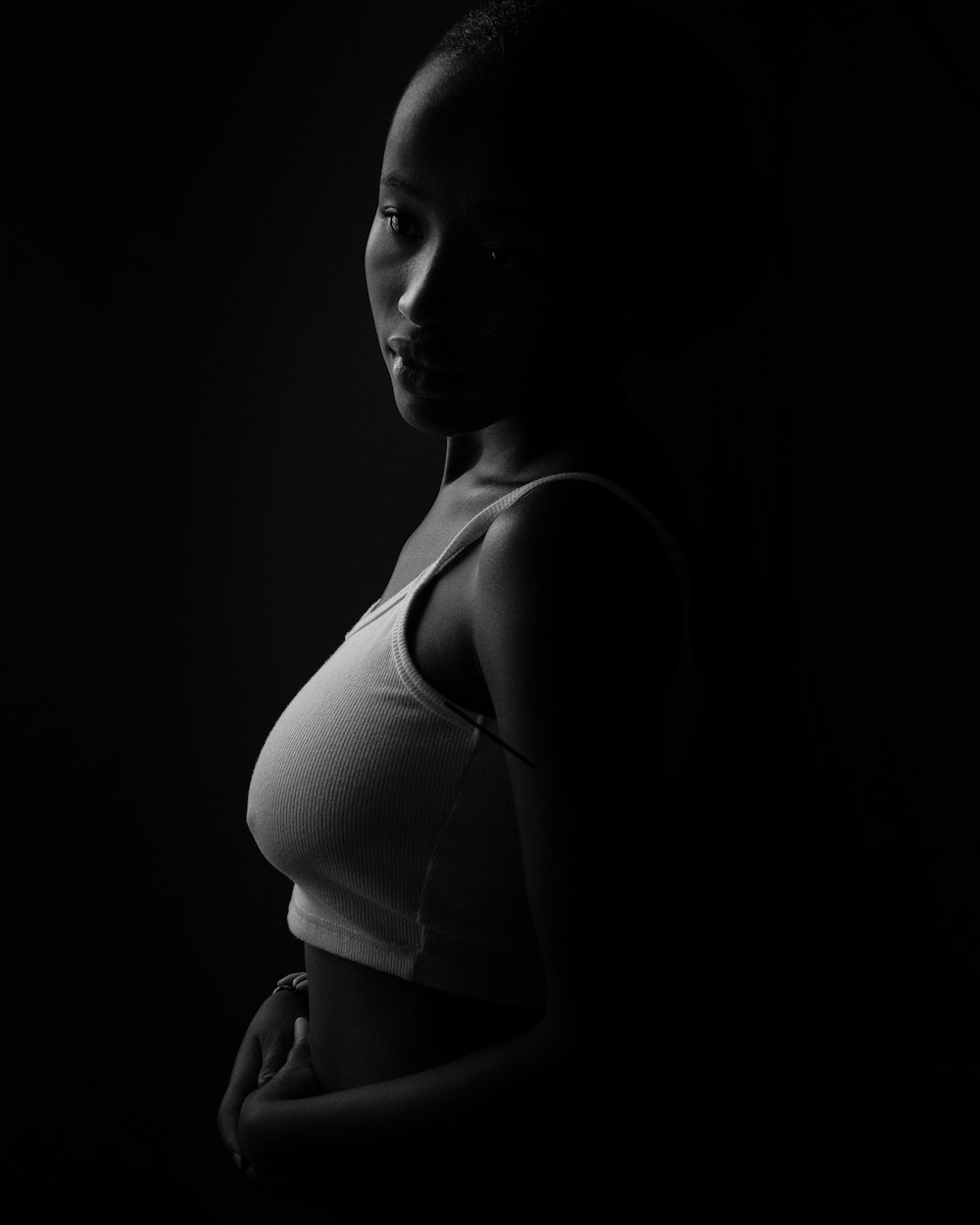 a black and white photo of a woman in a tank top