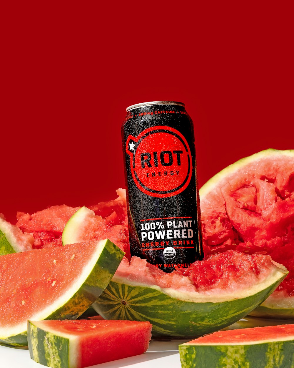 a can of riot watermelon next to slices of watermelon